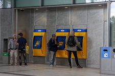 847240 Afbeelding van enkele vertwijfelde reizigers bij de automaten in de stationshal van Utrecht Centraal tijdens een ...
